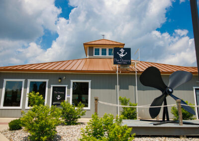 Front exterior of The Quarry Restaurant main entrance with blue sky and giant anchor out front