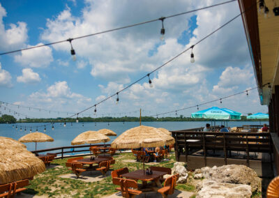 Outdoor back Patio at The Quarry restaurant with thatch umbrellas and tables and a deck