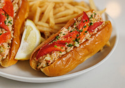 close up of Lobster Roll Sliders with fries on a white plate